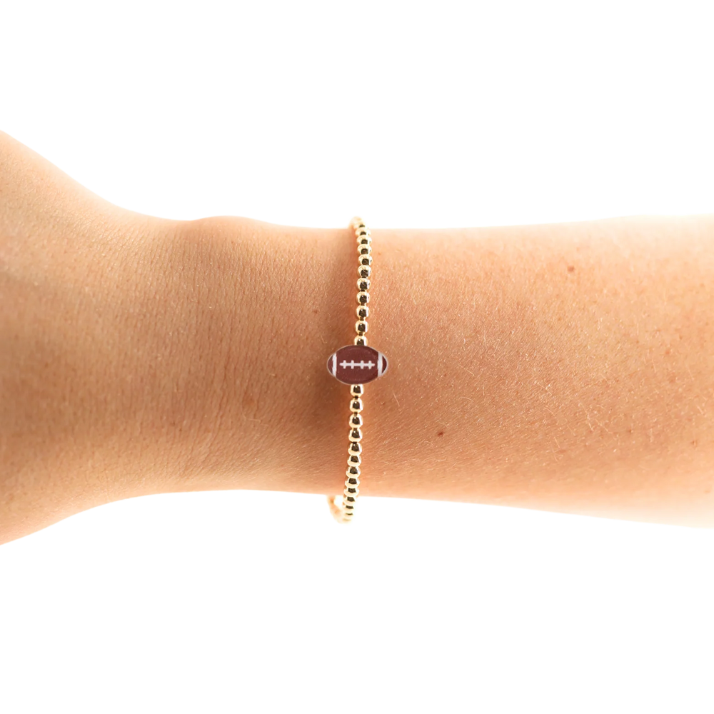 Beaded Blondes gold Bracelet with a football charm on a wrist 
