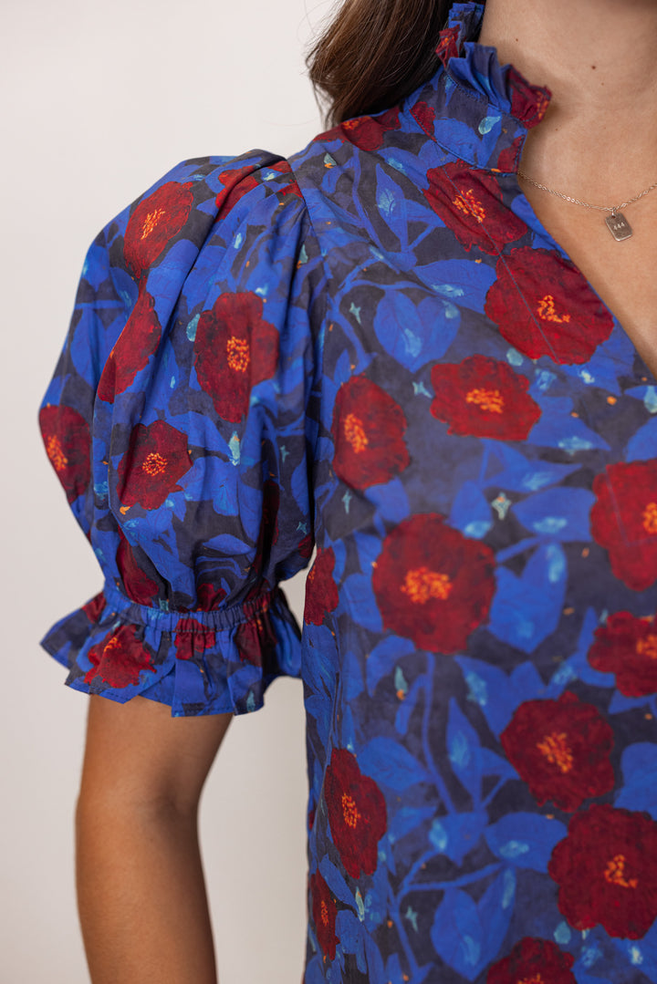 Dark blue puff sleeve top by Entro showing up close view of navy and burgundy floral print
