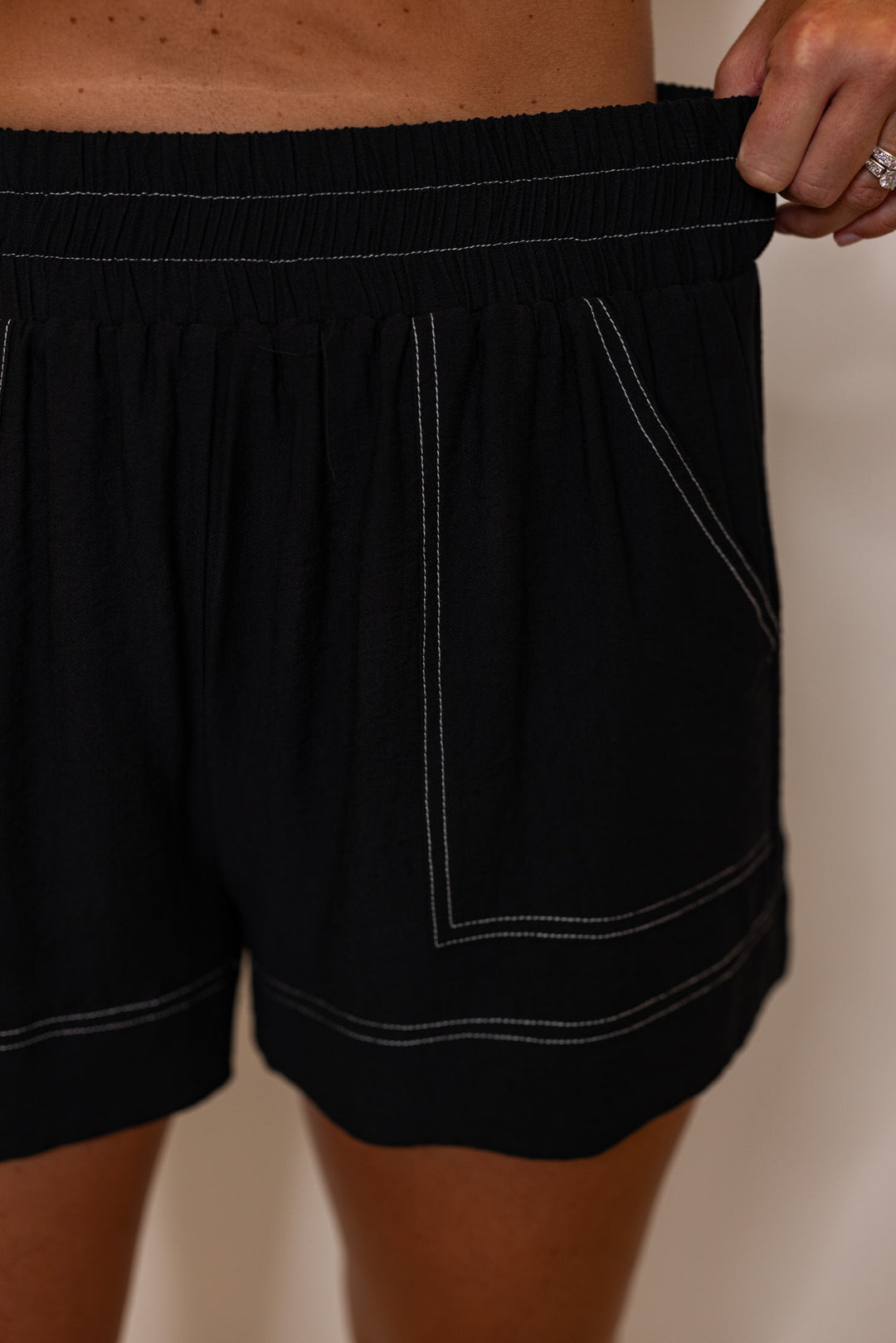 Black elastic waist shorts with white stitching by Entro showing elastic waistband