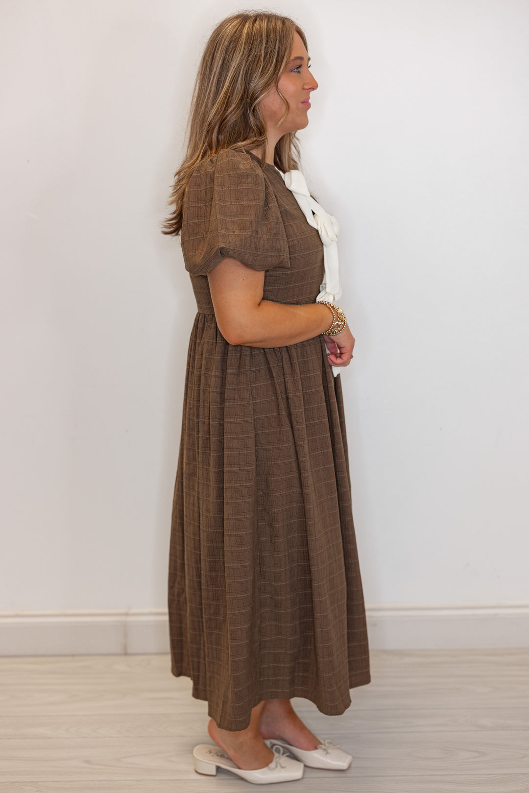 Women's brown check-textured monochrome midi dress with cream bows by In February showing full side view