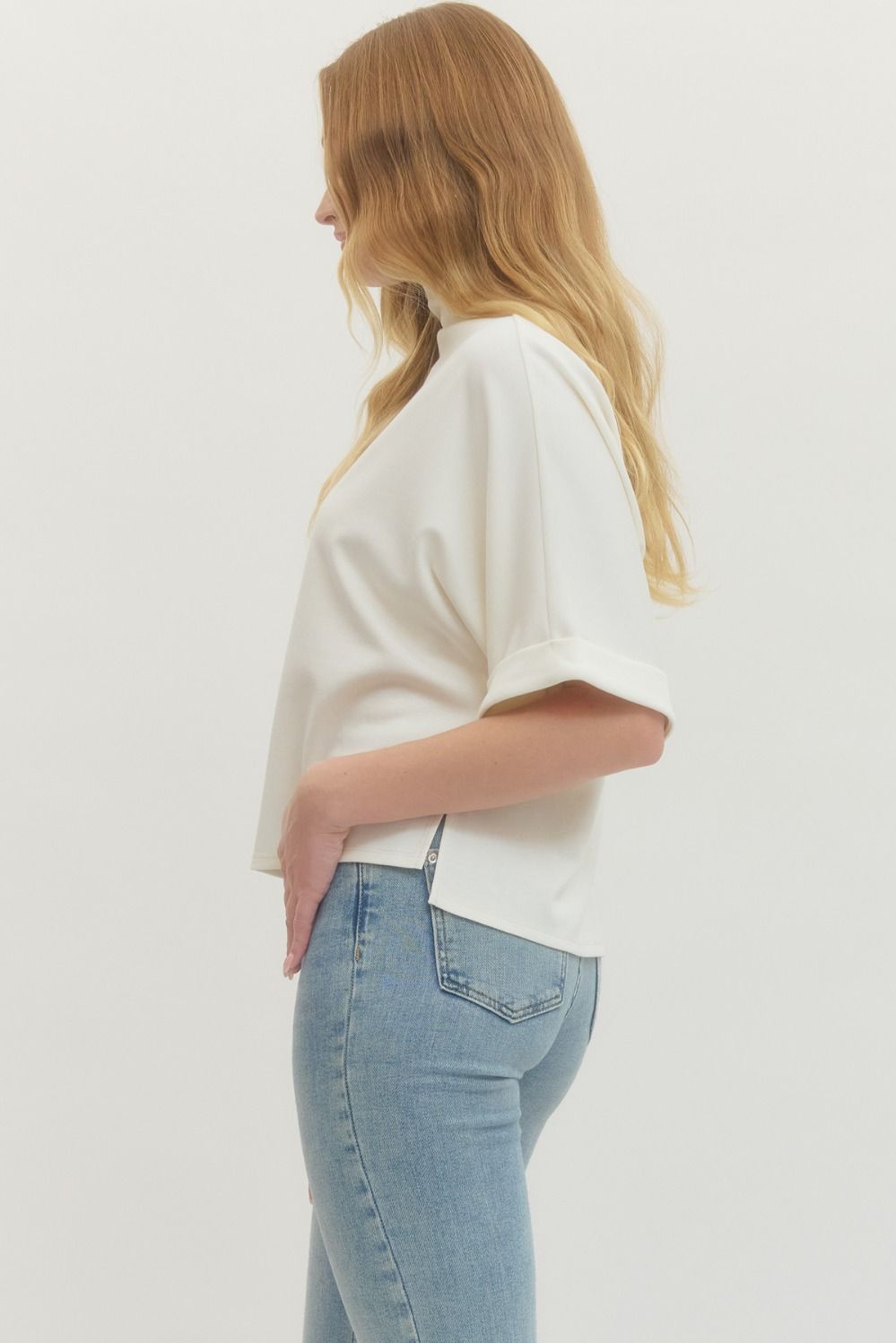 Women's cream scuba knit top with mock neck and dolman sleeves showing side slit