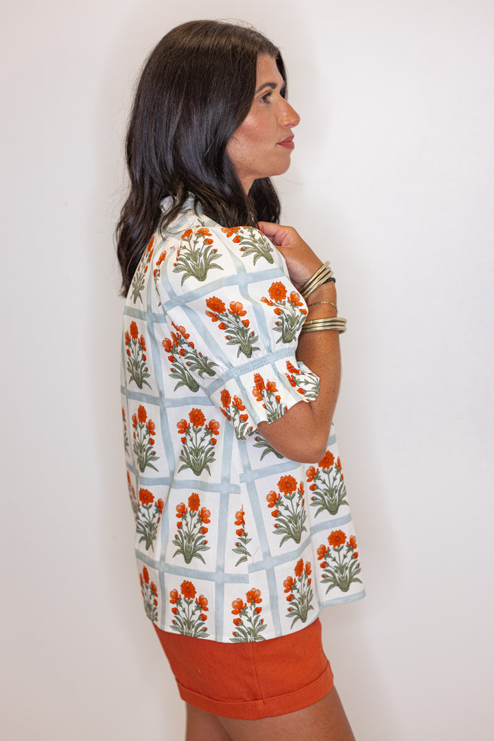 Cream top with orange floral print in light washed teal squares by Entro showing side view