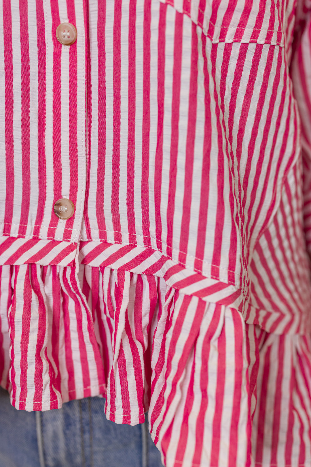 Women's pink summer striped button down top with ruffled bottom hem by Entro showing hem detailing