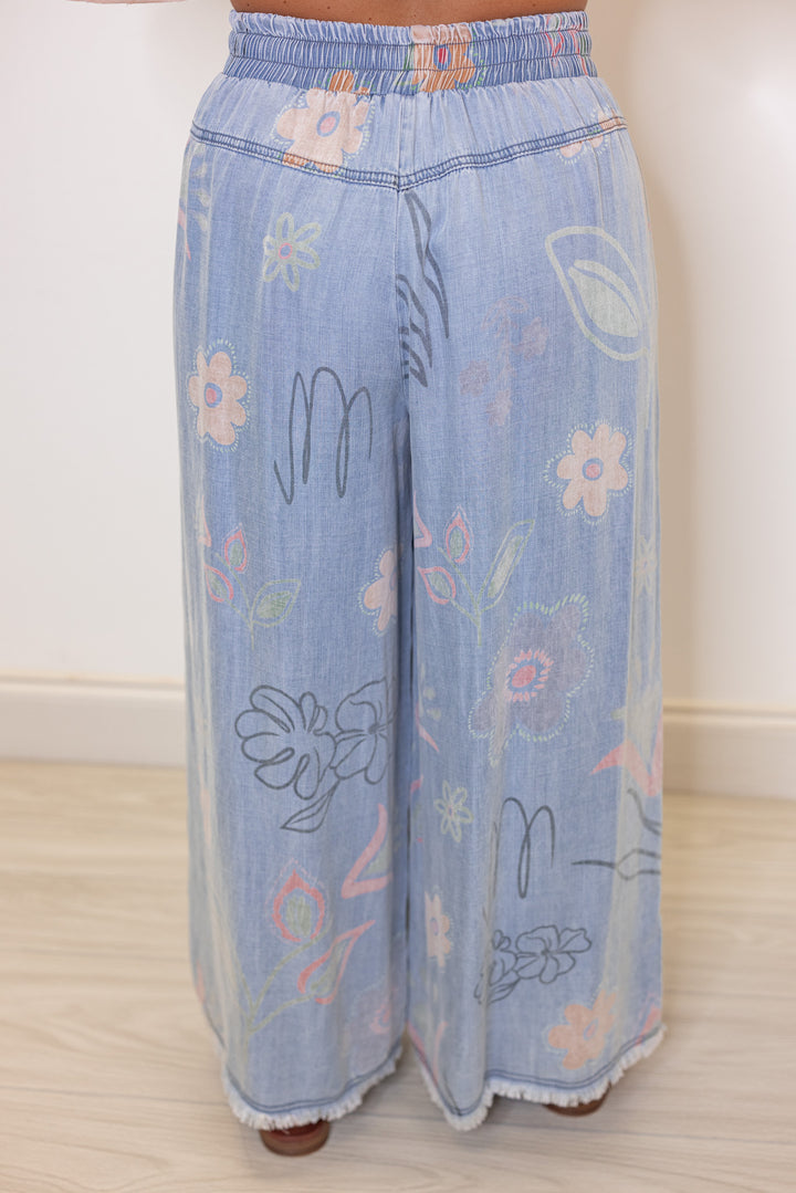 Women's washed light blue floral print wide leg palazzo chambray denim pants by Easel showing up close back view