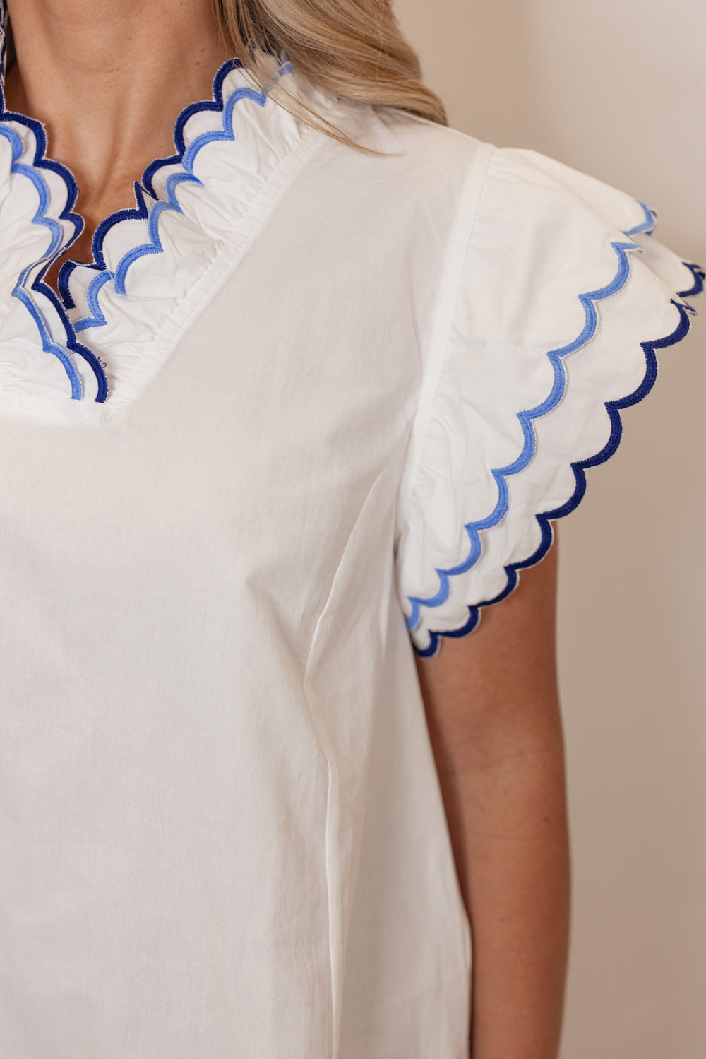 Women's summer off white poplin top with blue and navy scalloped trim by Umgee showing sleeve detailing