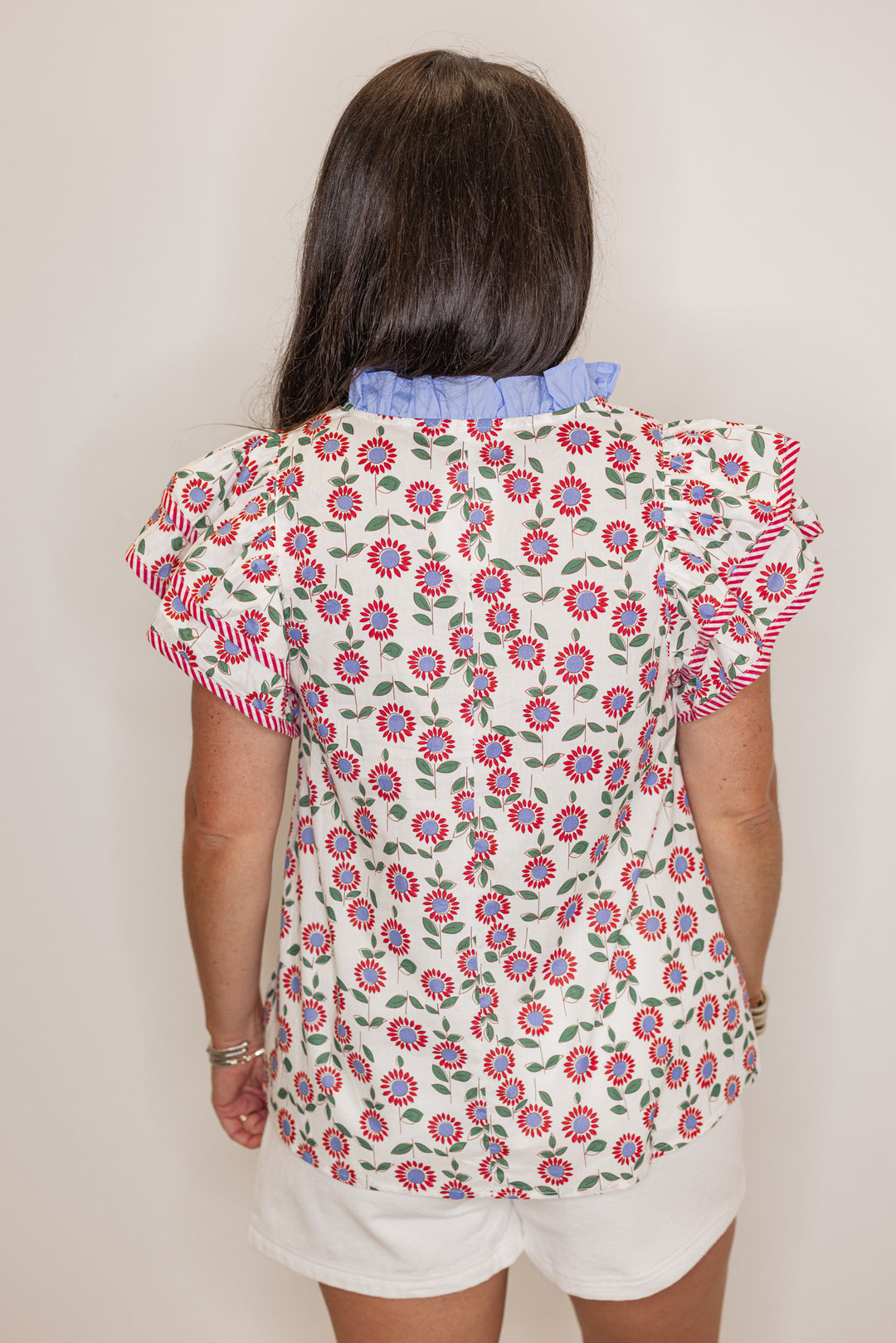 Women's cream poplin top with red, light blue and green floral print by Entro showing back view