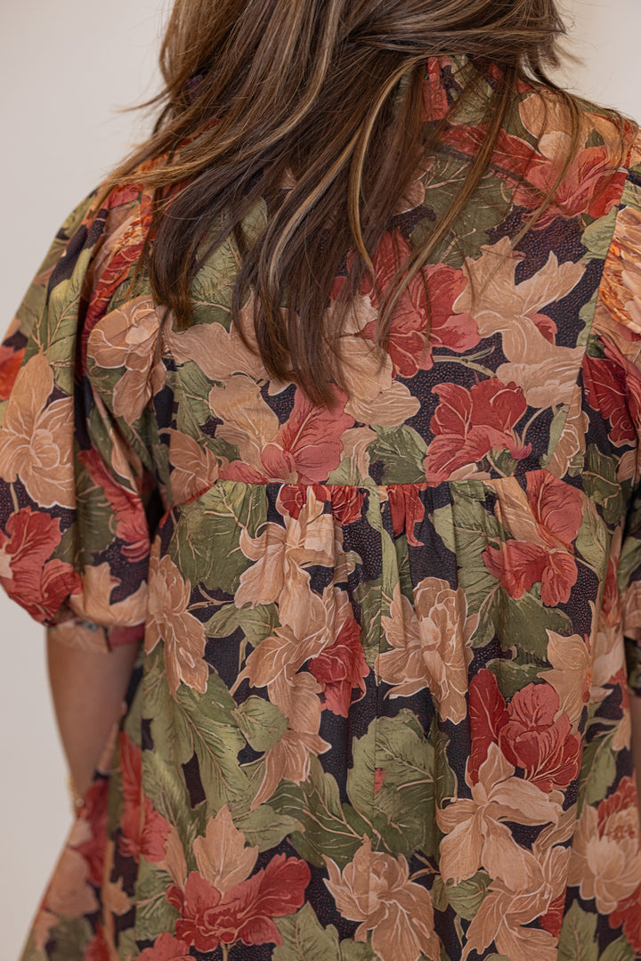 Women's brown babydoll dress with rusted burgundy, dusty peach and olive floral print by Entro showing up close back view
