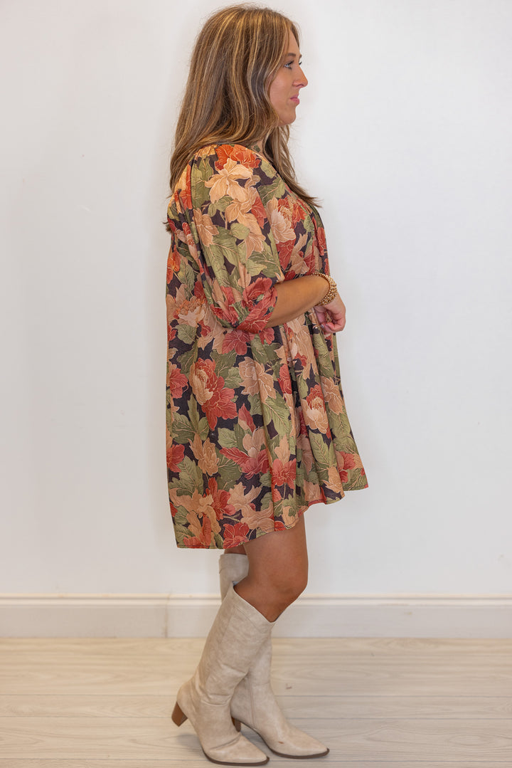 Women's brown babydoll dress with rusted burgundy, dusty peach and olive floral print by Entro showing full side view