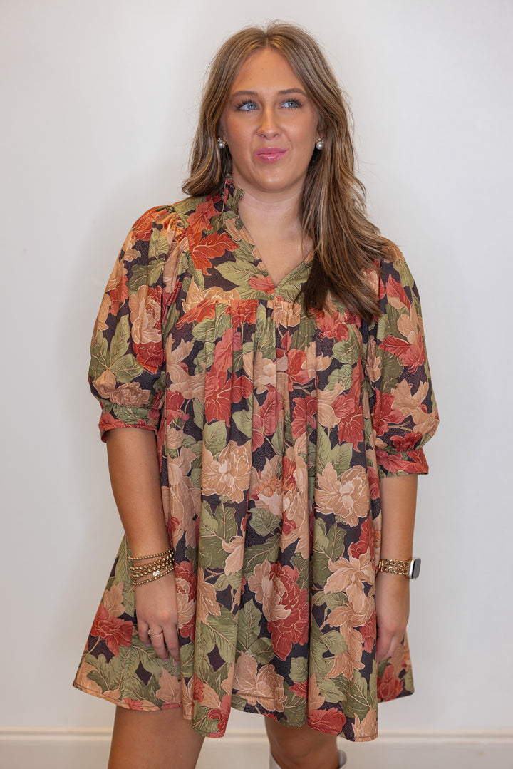 Women's brown babydoll dress with rusted burgundy, dusty peach and olive floral print by Entro showing up close front view