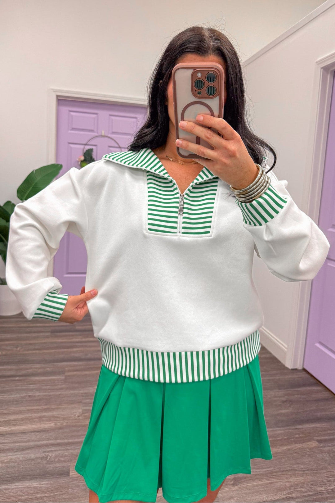 showing the fit of a women's white and green pullover 