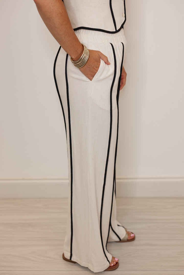 Women's natural linen wide leg pants with black striped trim by Illa Illa showing full side view