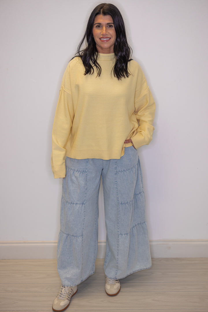 Women's trendy butter yellow knit mock neck top showing ruffled bottom hem